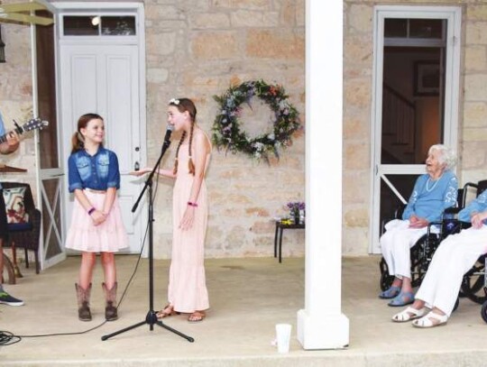 Phoebe and Stella Evans sing “You’ve Got a Friend in Me” while their dad, Jonah, accompanies on the guitar during last Saturday’s Herff twins 100th birthday celebration at Herff Farm. The trio are part of the huge Herff clan that gathered to celebrate Juanita Herff Chipman's and Carolyn He...