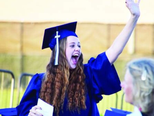 Champion graduate Kyra Bailey reacts and  waves as she recognizes someone coming into BISD Stadium before Thursday’s ceremony. Star photo by Keith E. Domke