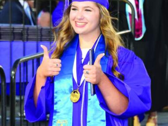 Emily Boerner is all smiles as she gives a thumbs up after receiving her diploma. Star photo by Keith E. Domke	  