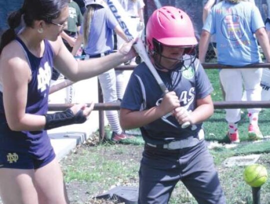 Boerne graduate and current Notre Dame softball player Mac Vasquez works with one of the campers during a hitting drill.