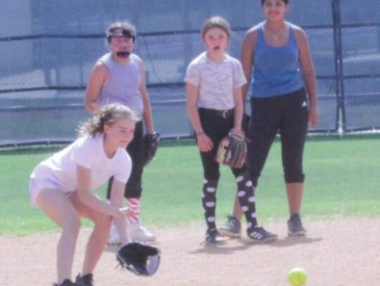 Young ladies work on infield grounders while at the camp.