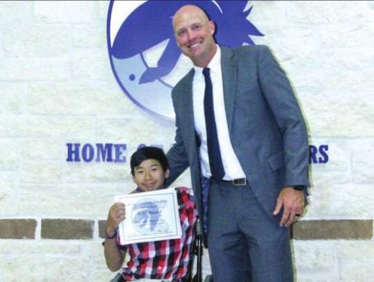 Ephrain Tonn-Bourg received the We Are Champion Award and poses for a photo with head track and field coach Blane Ellis. </br> Star photos by Kerry Barboza