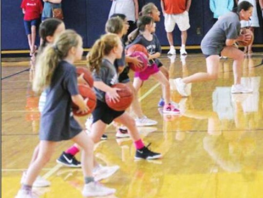 Boerne High School girls basketball coach Amy Ruede shows the campers the proper form on a jab step and has youngsters follow along in front of family and friends. </br> Star photo by Kerry Barboza