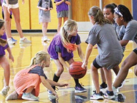 Former Charger player and camp coach Kristen Borgerding watches as the young ladies chase down a loose ball in the middle of the court. </br> Star photo by Kerry Barboza