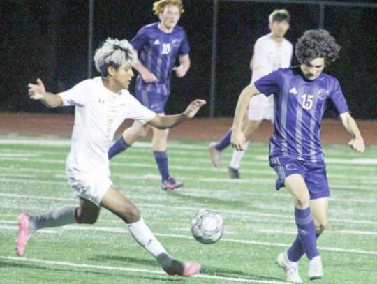 Ben Matamoros (15) and Bentley McCool (10) and the rest of the Champion boys soccer team compete against Buda Johnson in a district match.