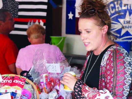 Carol Giles checks out all the potential raffle prizes. Star photo by Zachary-Taylor Wright