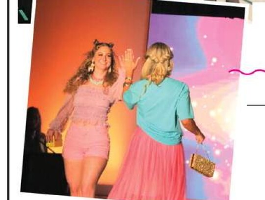 Audrey Potter and Danielle Kruciak, of La Te Da, share a show of support as they pass each other on the runway Saturday night.