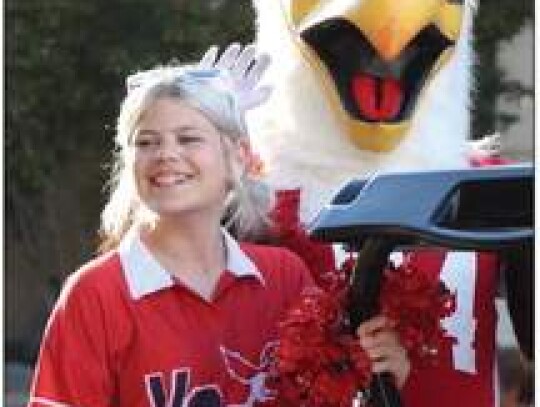 The Voss Middle School Eaglettes’ team manager, Acey Blomquist, waves and smiles to the crowd gathered at Main Plaza for the BHS Homecoming Parade as she serves in her official capacity escorting the team mascot, M.T. Eagle.