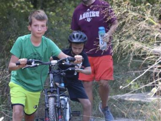 Justin worked hard to guide his two sons, Peter and James, up a hill off the Cibolo Creek Monday afternoon. Photos by Zachary-Taylor Wright