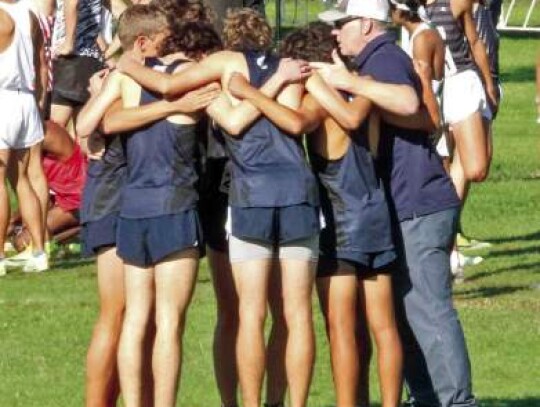 The Champion boys huddle with coach Jonathan Tate before the start of their race at the 5A state meet last Saturday. </br> Star photo by Kerry Barboza