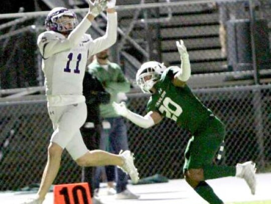 Greyhound receiver Brooks Perez (11) hauls in a pass over a Taylor defender during Thursday’s playoff contest in Marble Falls.