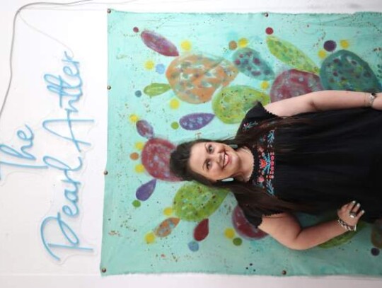 Reagan Harris stands proudly in front of artwork and a neon sign in her business, The Pearl Antler, new location at 322 S. Main St. Photos by Zachary-Taylor Wright