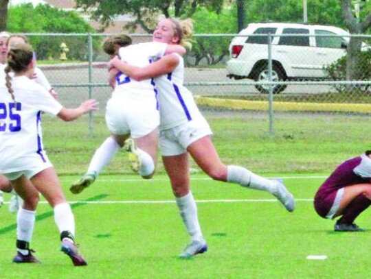 Boerne’s Sophia Harper gets a hug from Madeline Davis while other teammates come to celebrate after Harper put in the go-ahead and eventual game-winning goal against Davenport in the regional championship match with just over a minute left.