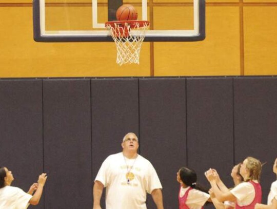 Champion girls basketball coach Jason Sanders watches as the campers go through a drill.