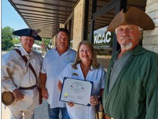 Immediate past president of the Boerne Sons of the American revolution, Pat Blackman, left, and current president Dale Tidwell, right, present a flag appreciation certificate to Kendall County Abstract Company president, Rick Pfeiffer and his wife, Ashlee