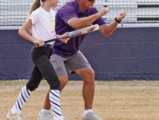 Boerne High softball coach Chester Pettibon gives a camper a few tips on bunting.