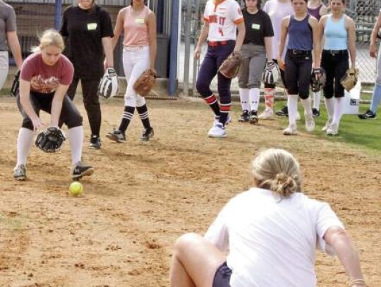 Champion coach Bethany Holtorf works with some of the young ladies on fielding grounders.