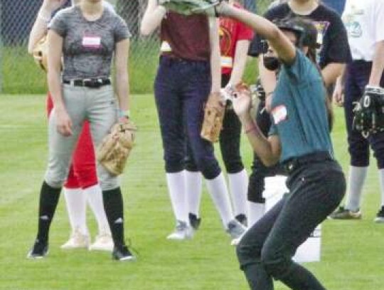 The youngsters work on catching fly balls in the outfield.