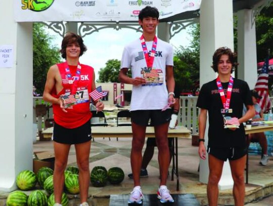 Gavin Chapa, 16, a Reagan High School student in San Antonio, was the overall winner of the Flag Run 5K in Boerne on July 4, with a time of 16:23. Second place went to Franco Parra, left, and third place to his twin brother, Marcelo Parra. Photos by Jeff 