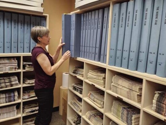 Kelly Skovbjerg, Patrick Heath Public Library director, begins removing bound back issues of The Boerne Star from the newspaper’s “morgue” on Monday. The issues are being digitized through a Texas State Library and Archives grant. Photo by Jeff B. F