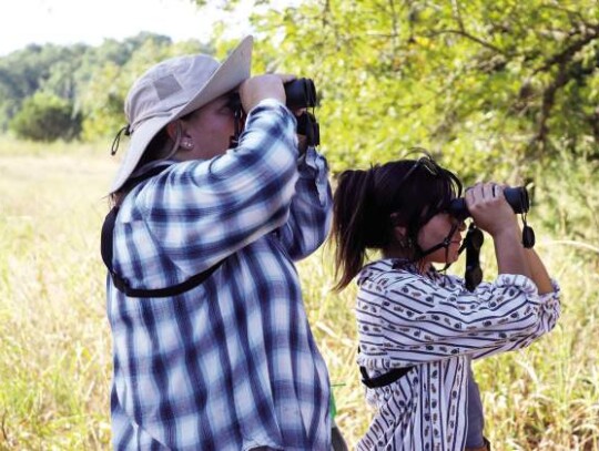 Darla Reid (left) and Bri Corpus train their binoculars toward trees along a path in the Cibolo Nature Center. The two took part in Monday’s monthly Nature Center Bird Survey.