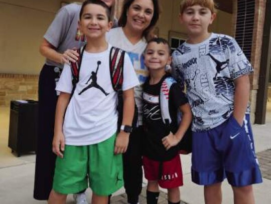 Herff Elementary Principal Jennifer Hammond (rear left) welcomes Dena Tripodo and her boys, fifth-grader Nico (left) and second-grader Lucas (center) back to Herff Elementary Thursday. Douglas Tripodo attends Boerne Middle School North.
