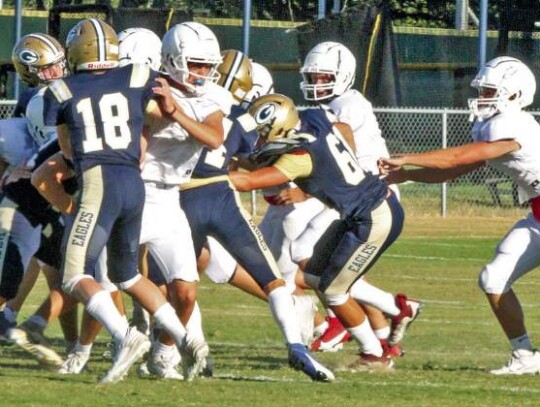 Members of the Geneva School of Boerne defense combine to make a tackle during last Friday’s scrimmage with Hyde Park. </br> Star photo by Kerry Barboza