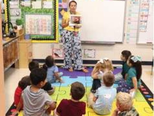 Yvonne Gonzalez goes over a booklet reviewing classroom rules and behavior with students in her Comfort Elementary School kindergarten class. Photos by Jeff B. Flinn.