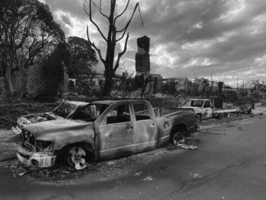 Charred vehicles sit in front of what’s left – the brick chimney -- of the two-story home in Lahaina, Maui, where Tait Maxfeldt and Jaime Rae Kasztelan lived on the second floor. Courtesy Photo